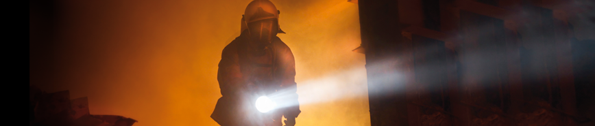A Firefighter carries a handlamp